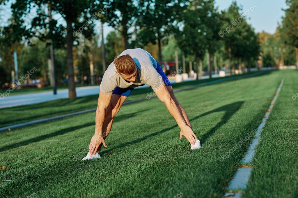 Sporty man in the park on the lawn exercise lifestyle. High quality photo