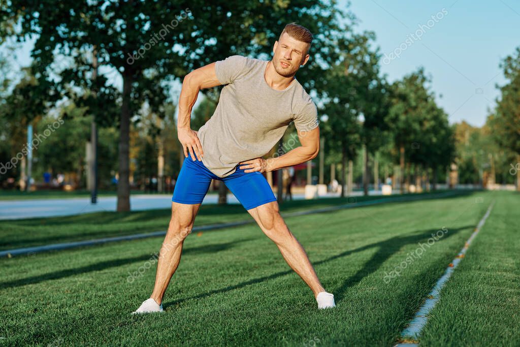 Sporty man in the park on the lawn exercise lifestyle. High quality photo