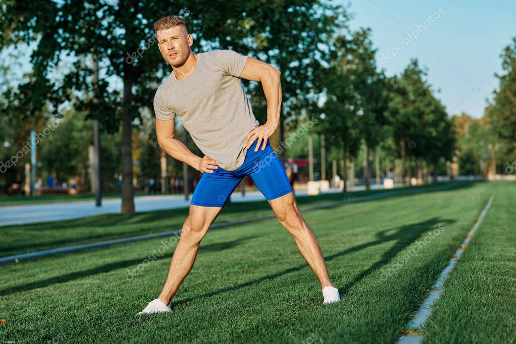 Sporty man in the park on the lawn exercise lifestyle. High quality photo