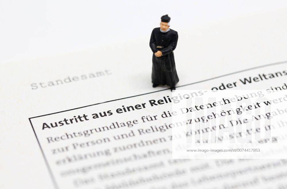 Nuernberg Symbolfoto, Themenbild Kirchenaustritt, Kirchensteuer. Geistlicher mit Soutane steht auf Formular fuer Kirchenaustritt.