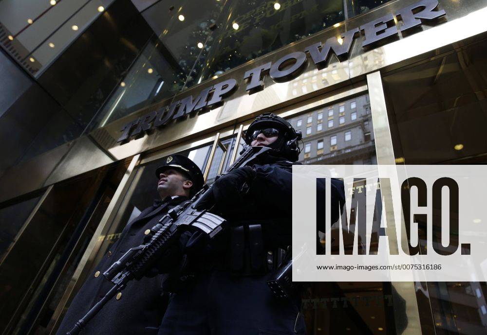 New York, New York, United States of America - An armed NYPD police officer stands guard outside the entrance to Trump Tower on December 11, 2016 in New York City. U.S. President-elect Donald Trump is still holding meetings upstairs at Trump Tower as he continues to fill in key positions in his new administration. .Credit: Pool via CNP New York United States of America - ZUMAs152 20161211_zaa_s152_001
