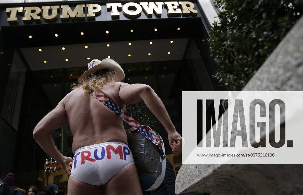 New York, New York, United States of America - An American street musician known as Naked Cowboy plays guitar outside at the entrance to Trump Tower on December 11, 2016 in New York City. U.S. President-elect Donald Trump is still holding meetings upstairs at Trump Tower as he continues to fill in key positions in his new administration. .Credit: Pool via CNP New York United States of America - ZUMAs152 20161211_zaa_s152_002