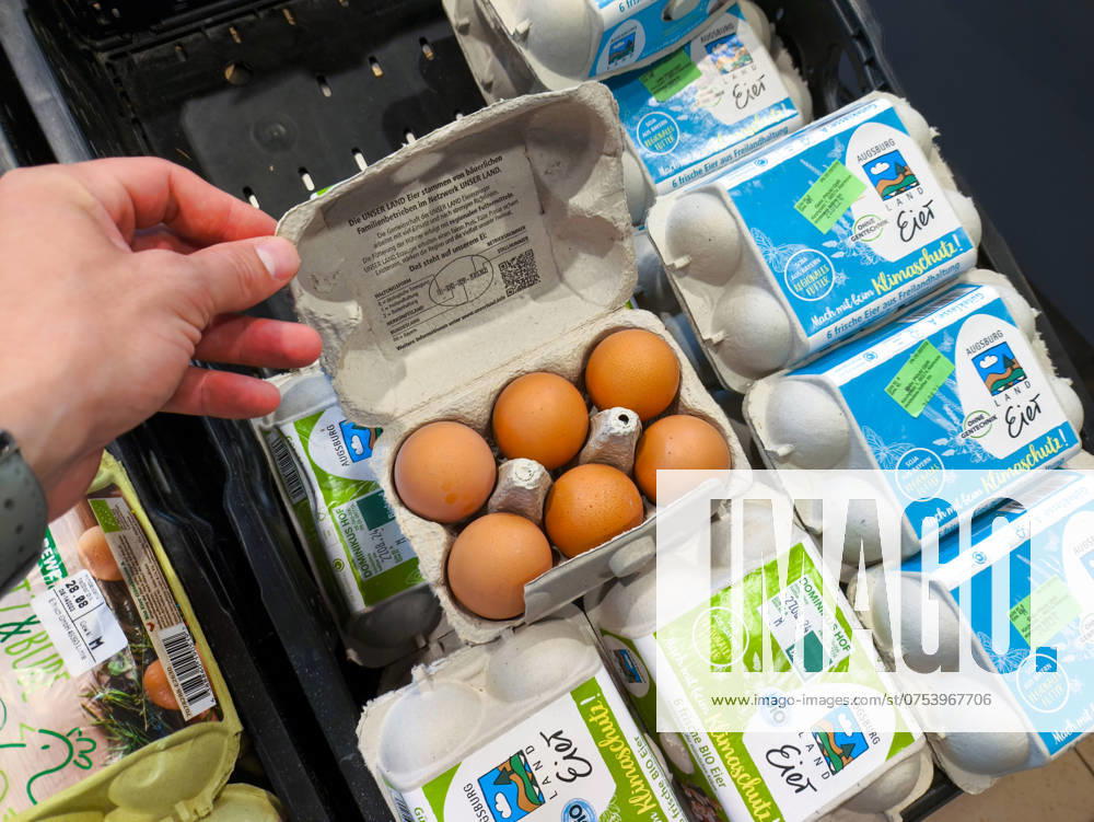 Ein Kunde öffnet eine Eierschachtel im Supermarkt, um die Frische und Qualität der Eier vor dem Kauf zu überprüfen