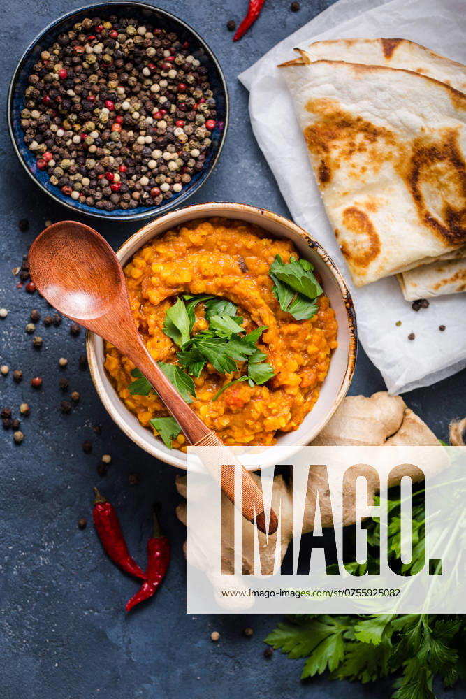 Traditionelle indische Linsen Dal, Naan Butterbrot, frischer Koriander. Indische Dhal würzigen Curry in Schüssel, Gewürze, Kräuter, rustikalen Beton Hintergrund. Ansicht von oben. Indisches Essen. Authentisches indisches Gericht. Draufsicht Traditional Indian lentils Dal, naan butter bread, fresh coriander. Indian Dhal spicy curry in bowl, spices, herbs, rustic concrete background. Top view. Indian food. Authentic Indian dish. Overhead