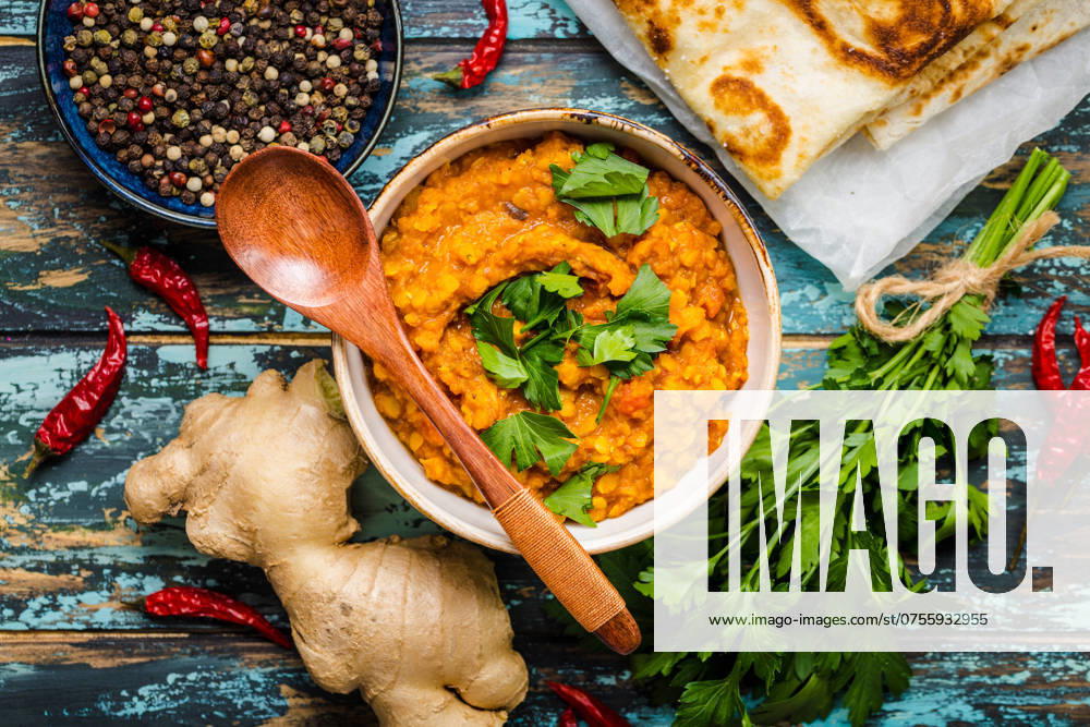 Traditionelle indische Linsen Dal, Naan Butterbrot, frischer Koriander. Indische Dhal würzigen Curry in Schüssel, Gewürze, Kräuter, rustikalen hölzernen Hintergrund. Ansicht von oben. Indisches Essen. Authentisches indisches Gericht. Draufsicht Traditional Indian lentils Dal, naan butter bread, fresh coriander. Indian Dhal spicy curry in bowl, spices, herbs, rustic wooden background. Top view. Indian food. Authentic Indian dish. Overhead