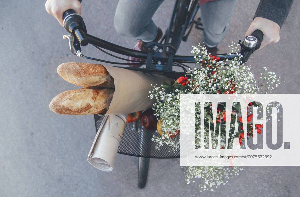 IMAGO Creative, Urban Lifestyle Man with apples, bouquet of flowers, newspaper and baguettes in bicycle basket model released Symbolfoto RTBF00557