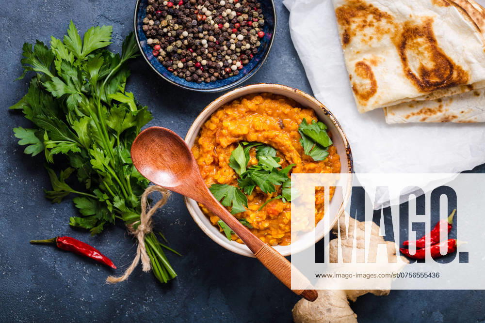 Traditionelle indische Linsen Dal, Naan Butterbrot, frischer Koriander. Indische Dhal würzigen Curry in Schüssel, Gewürze, Kräuter, rustikalen Beton Hintergrund. Ansicht von oben. Indisches Essen. Authentisches indisches Gericht. Draufsicht Traditional Indian lentils Dal, naan butter bread, fresh coriander. Indian Dhal spicy curry in bowl, spices, herbs, rustic concrete background. Top view. Indian food. Authentic Indian dish. Overhead