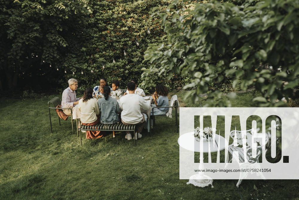 IMAGO Creative, Lifestyle, Feste im Garten #2 High angle view of male and female family members having dinner during social gathering in back yard Sweden, Gothenburg, model released, property released
