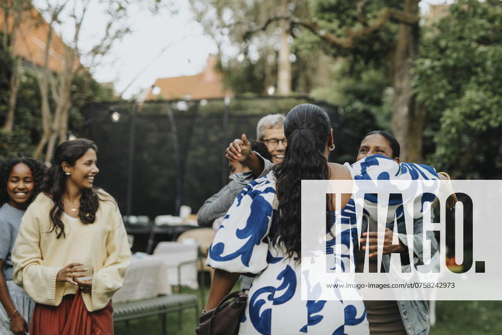 IMAGO Creative, Lifestyle, Feste im Garten #2 Family members greeting each other during social gathering in back yard Sweden, Gothenburg, model released, property released