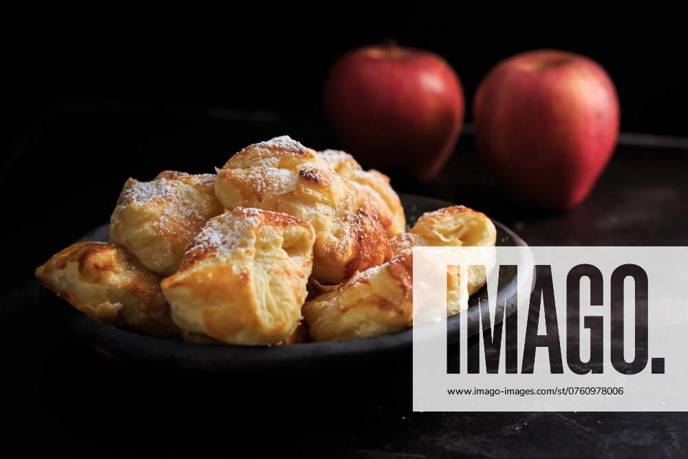 IMAGO Creative, Food, Gebäck, Apfeltaschen Hausgemachte kleine Apfeltaschen in einer Schüssel auf schwarzem Hintergrund Homemade small apple turnovers in bowl on black background
