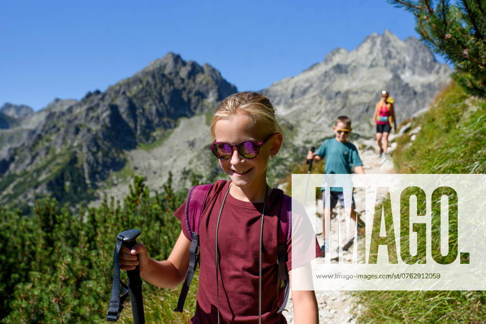 Grandmother with grandchildren on hike in autumn mountains, walking down the hiking trail. Kids spending summer break in nature with family. Grandmother with grandchildren on hike in autumn mountains, walking down the hiking trail. Kids spending summer break in nature with a family. model released