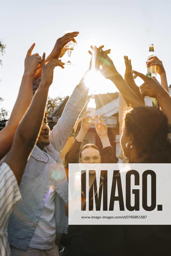 IMAGO Creative, Lifestyle, Feste im Garten #2 Multiracial group of male and female friends with hands raised enjoying in back yard on sunny day at social party Sweden, Stockholm, model released, property released