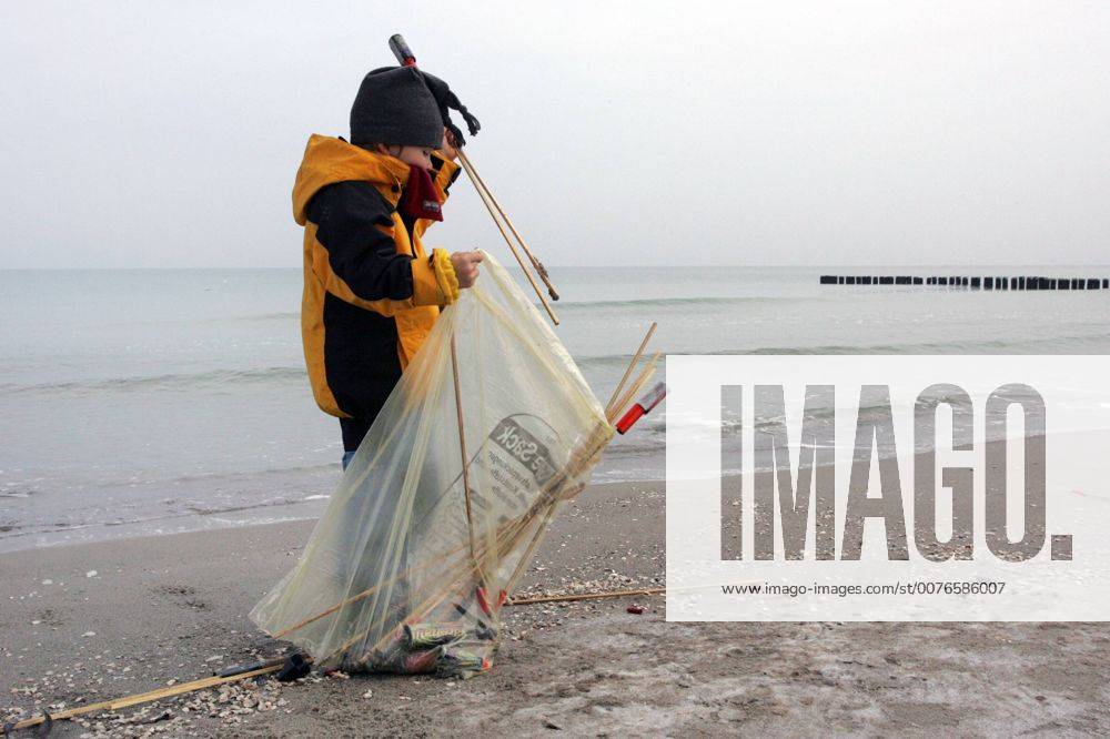 Zingst, Mecklenburg-Vorpommern, DEU - Ein Kind sammelt abgebrannte Silvesterraketen am Strand ein. (1. Januar, Erster, Jahresanfang, Jahresbeginn, Jahreswechsel, Januar, Neujahr, Rakete, Raketen, Silvester, Silvesterrakete, Silvesterraketen, Muell, Abfall, Unrat, Muellsack, sammeln, einsammeln, Oekologie, oekologisch, Rest, Reste, Ueberreste, Ueberbleibsel, Umwelt, Umweltschutz, Umweltbewusstsein, umweltbewusst, Muelltuete, Strand, Meer, Wasser, Winter, abgebrannt, abgefeuert, Mensch, Kind, Kindheit, Gesellschaft, Lebenswelt, Lebenswelten, Ostsee, Zingst, Darss, Aussenaufnahme, digital, QF, gefährlich, Müll, Müllsack, Ökologie, ökologisch, Mülltüte, Überbleibsel, Überreste) 00S060101D001.JPG MODEL RELEASE: YES MR:Y