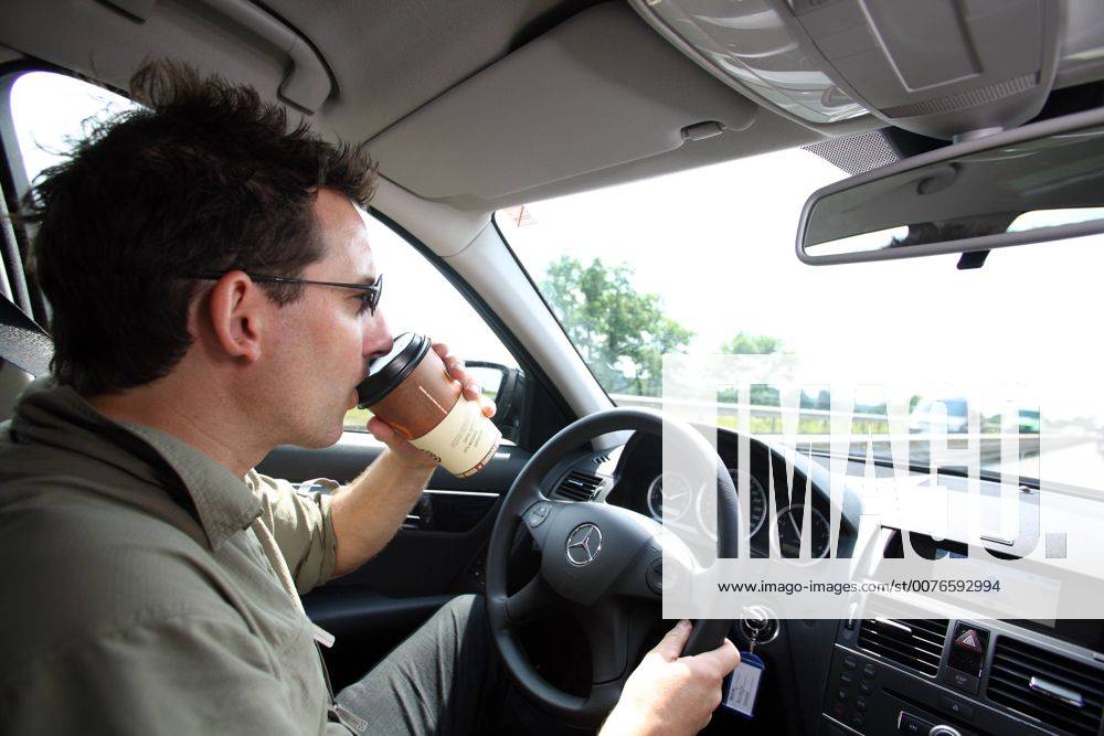 Hamburg, Hansestadt Hamburg, Deutschland - Mann trinkt Kaffee beim Autofahren. (Hamburg, Hansestadt Hamburg, Deutschland, deutsch, Europa, 30-40 Jahre, Auto, Auto fahren, Autobahn, autofahren, Autofahrer, Autofahrt, Autoverkehr, Fahren, Gesellschaft, Kraftfahrer, Lenker, Mann, Mensch, Kaukasier, kaukasisch, PKW, Strasse, Strassenverkehr, Verkehrsteilnehmer, Wagen, faehrt, fahren, fahrend, Emotion, Becher, Durst, durstig, Getraenk, Heissgetraenk, Koffein, Muedigkeit, vorbeugen, Vorbeugung, Kaffee, Kaffeebecher, trinken, Essen und Trinken, Konzentration, konzentriert, QF, fährt, Getränk, Heissgetränk, Müdigkeit) 00S080701D009.JPG MODEL RELEASE: YES, PROPERTY RELEASE: NO MR:Y