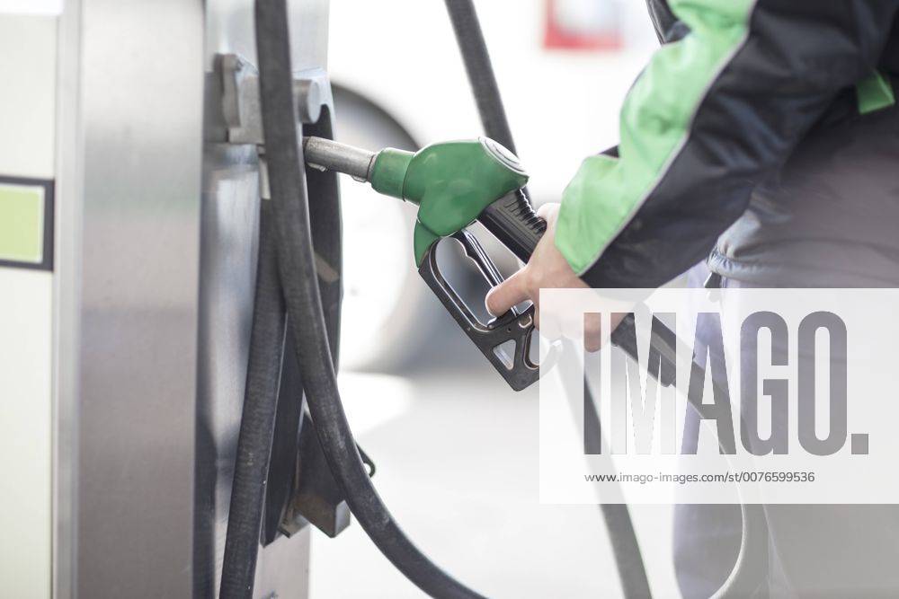 Petrol attendant holding petrol pump model released Symbolfoto property released ZEF12304