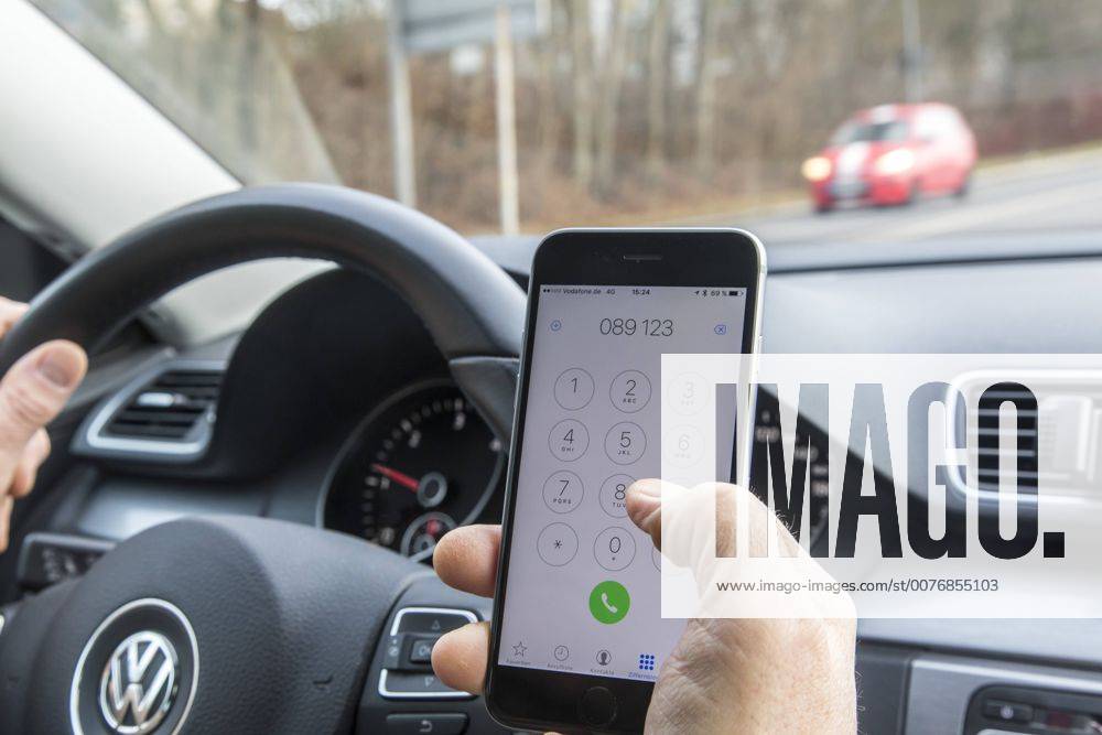 Mann, Autofahrer, benutzt ein Handy, während der Fahrt, wählt Telefonnummer, ohne Freisprecheinrichtung,