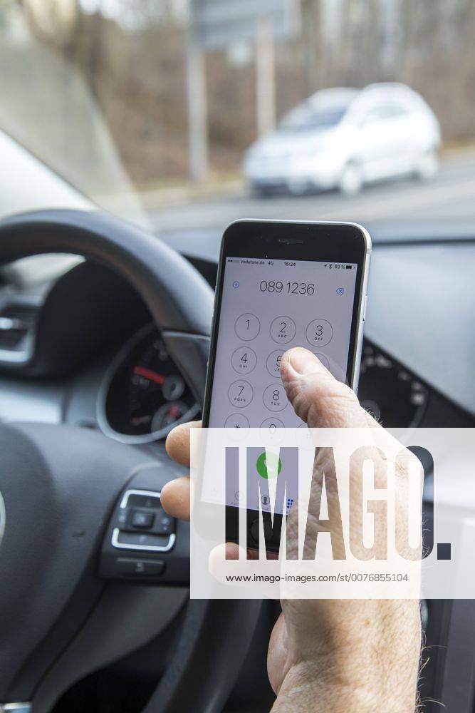 Mann, Autofahrer, benutzt ein Handy, während der Fahrt, wählt Telefonnummer, ohne Freisprecheinrichtung,