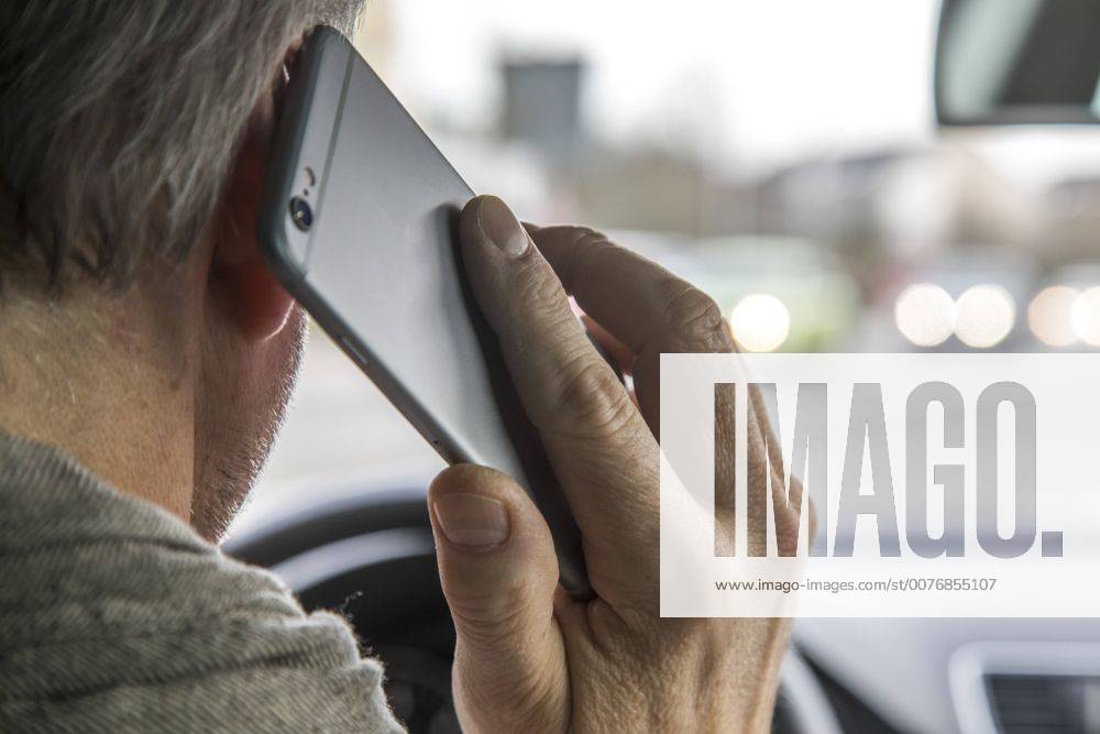 Mann, Autofahrer, benutzt ein Handy, während der Fahrt, ohne Freisprecheinrichtung,