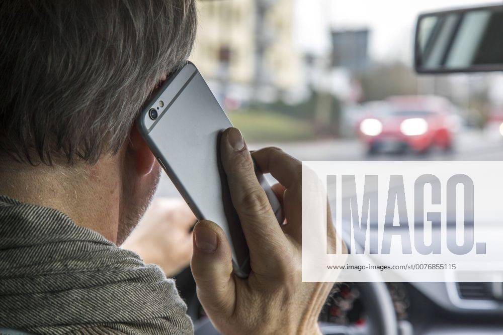 Mann, Autofahrer, benutzt ein Handy, während der Fahrt, ohne Freisprecheinrichtung,