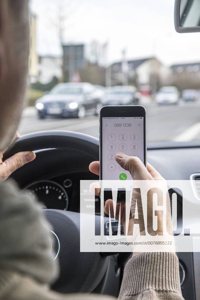 Mann, Autofahrer, benutzt ein Handy, während der Fahrt, wählt Telefonnummer, ohne Freisprecheinrichtung,