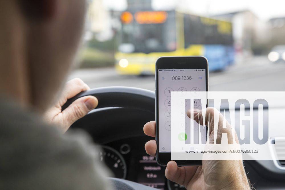 Mann, Autofahrer, benutzt ein Handy, während der Fahrt, wählt Telefonnummer, ohne Freisprecheinrichtung,