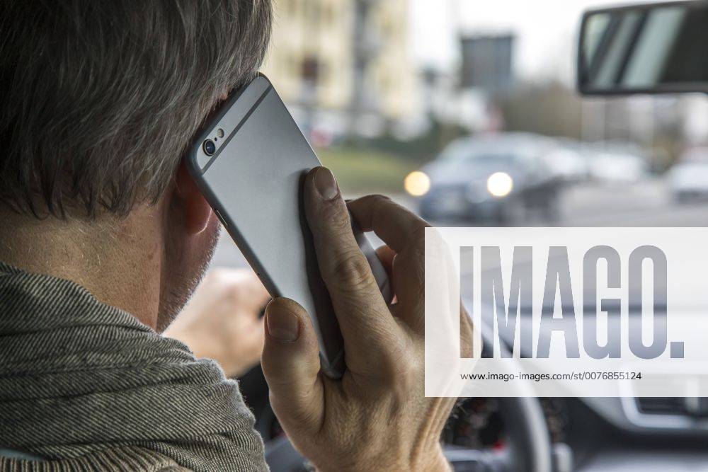 Mann, Autofahrer, benutzt ein Handy, während der Fahrt, ohne Freisprecheinrichtung,