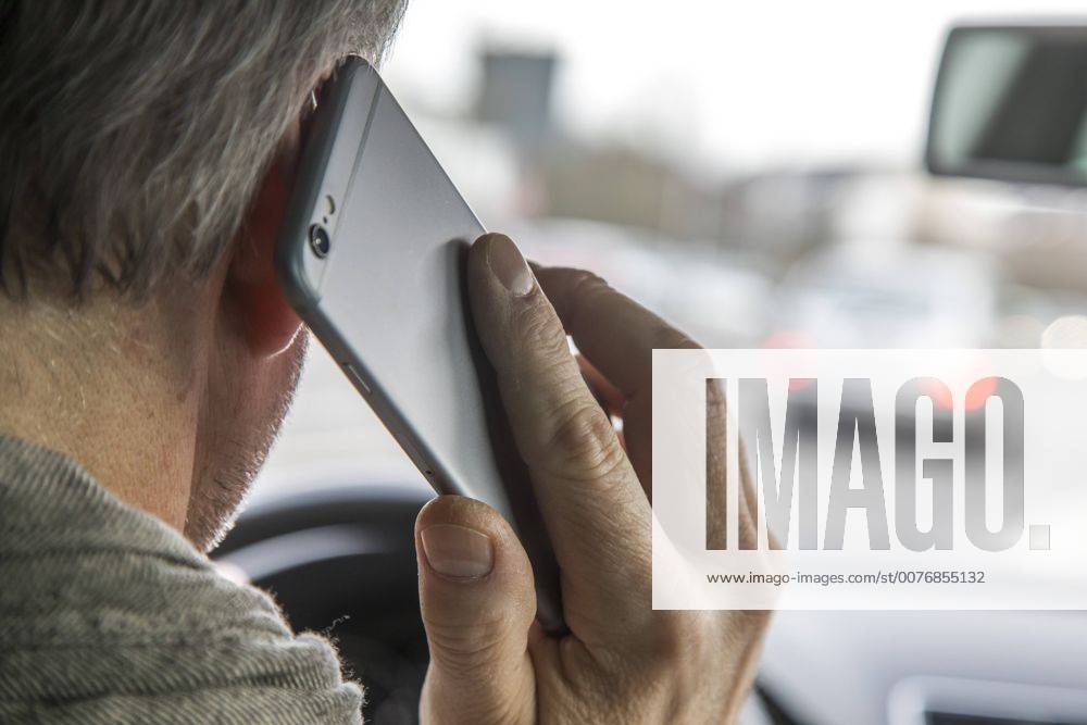 Mann, Autofahrer, benutzt ein Handy, während der Fahrt, ohne Freisprecheinrichtung,