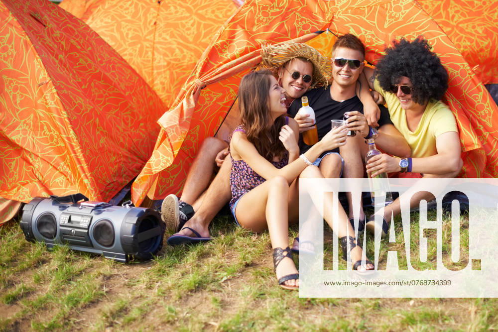 People, music festival and drinks by tent, excited and relax wellness in nature with friends. Men, woman or happy at social celebration for concert, weekend vacation or bonding in summer fun at party. model released property released