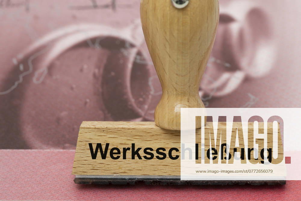 AUDI-Krise mit Gefahr der Werksschließung Ein Holzstempel ist beschriftet mit dem Aufdruck: Werksschließung, über einer AUDI-Aktie - Symbolbild