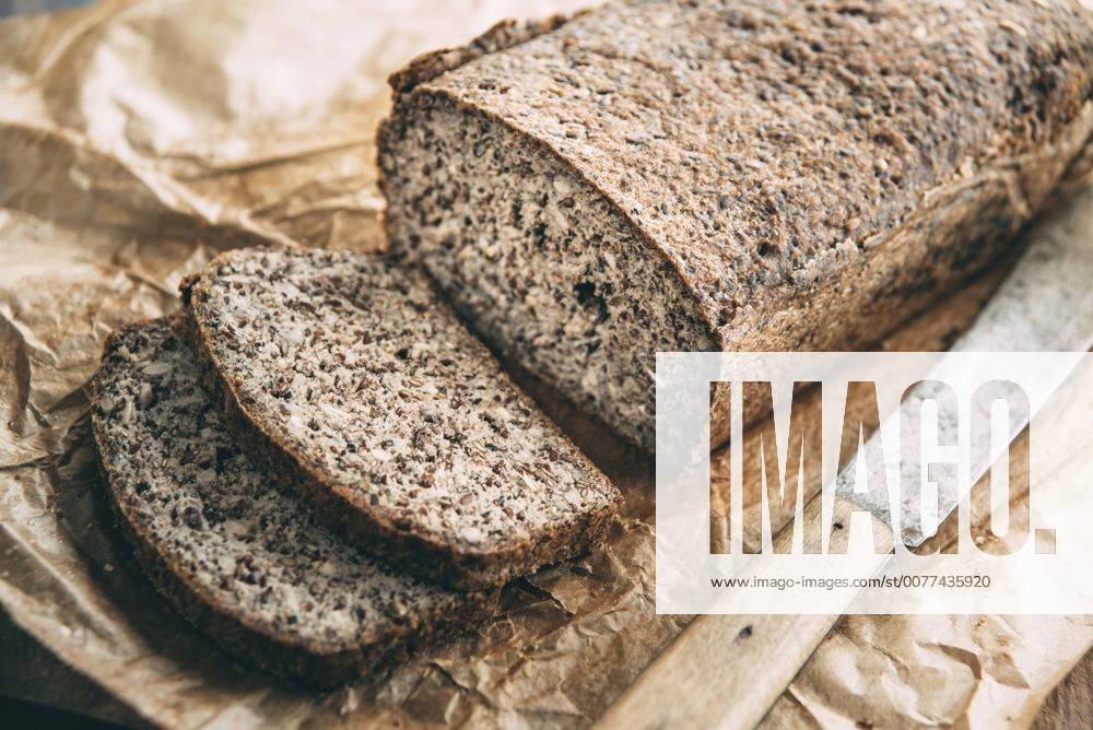 Home-baked wholemeal glutenfree bread and bread knife on brown paper IPF00354