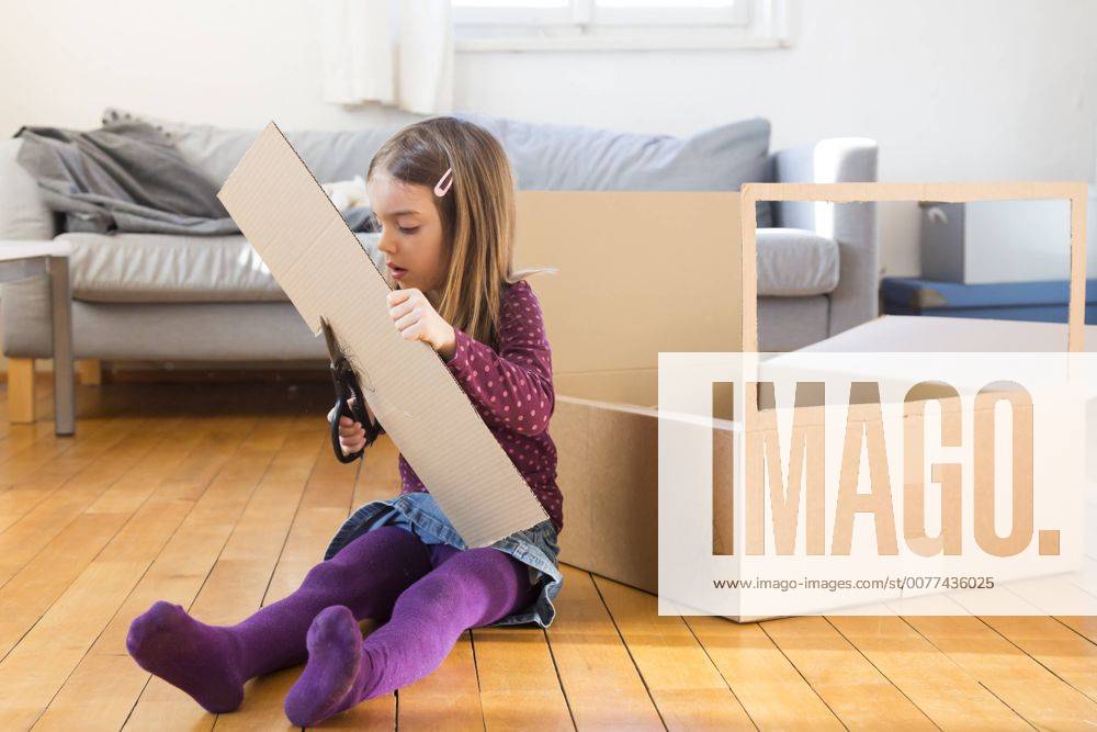 Girl tinkering with cardboard box at home model released Symbolfoto LVF05805