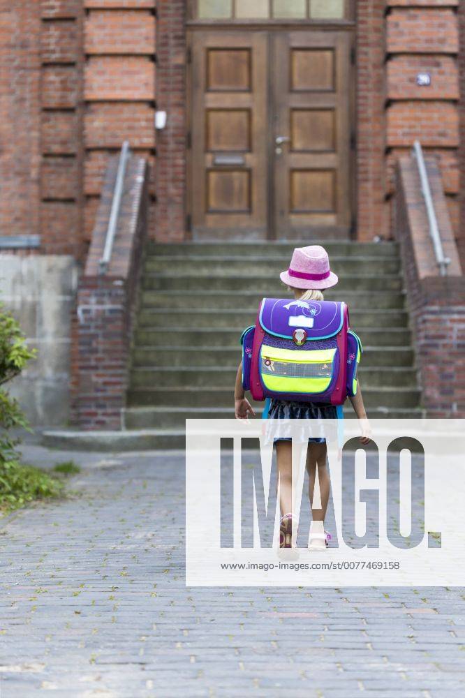 IMAGO Creative: Gesellschaft, Schule, Schulanfang Back view of little girl with school bag in front of her school model released Symbolfoto JFEF00836