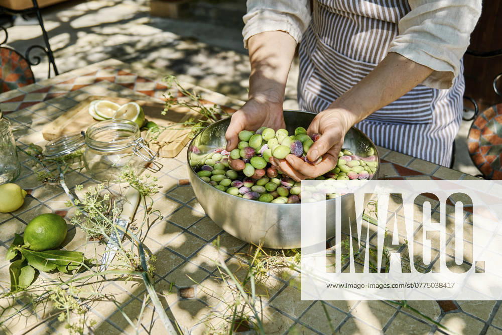 Mature woman washing olives in big metal bowl model released, Symbolfoto property released, CATF00444