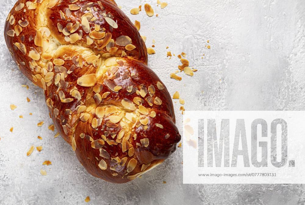 Geflochtener, süßer Brotkuchen, mit gehobelten Mandeln, Frühstück, geflochtenes Brot, Brioche, auf einem hellen Hintergrund, Draufsicht, keine Personen Braided, sweet bread pie, with sliced almonds, breakfast, braided bread, brioche, on a light background, top view, no people