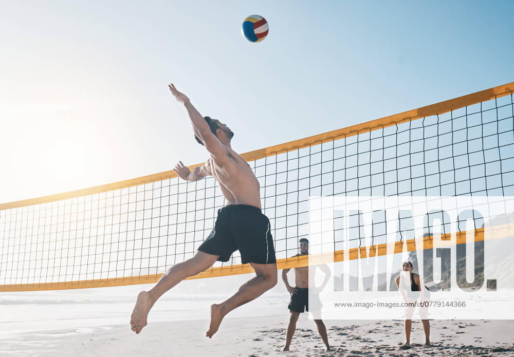 Man, jump and volleyball in air on beach by net in sports match, game or competition. Body of male person jumping for ball in volley or spike in healthy fitness, energy or exercise by the ocean coast. model released property released