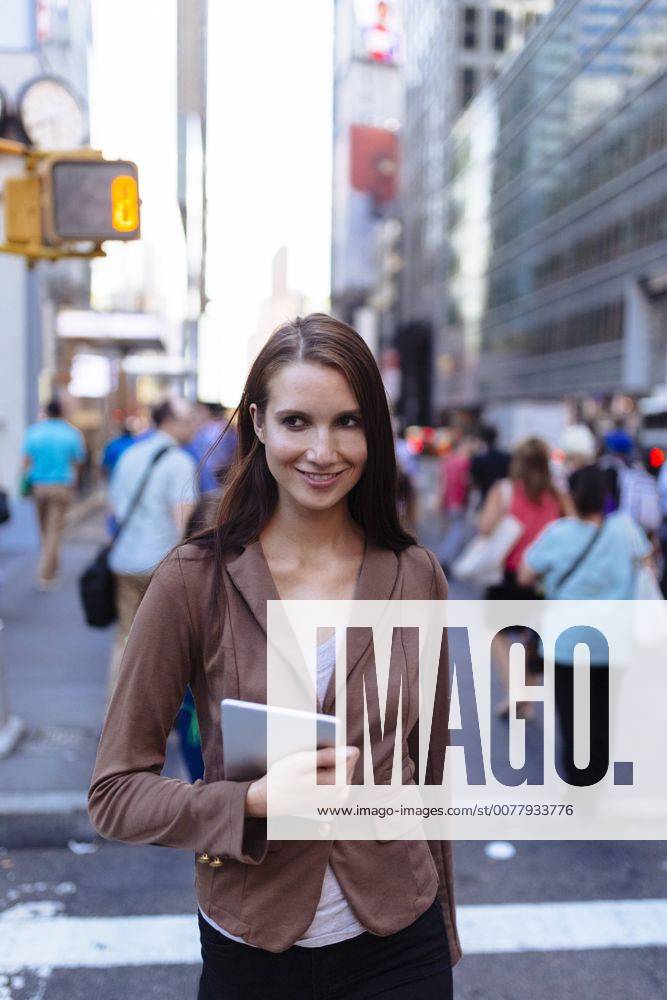 USA, New York, Manhattan, portrait of young businesswoman with tablet crossing the street model released Symbolfoto BOYF00708