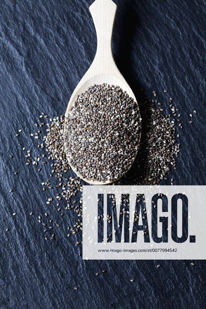 Wooden spoon of black chia seeds on slate CSF28016