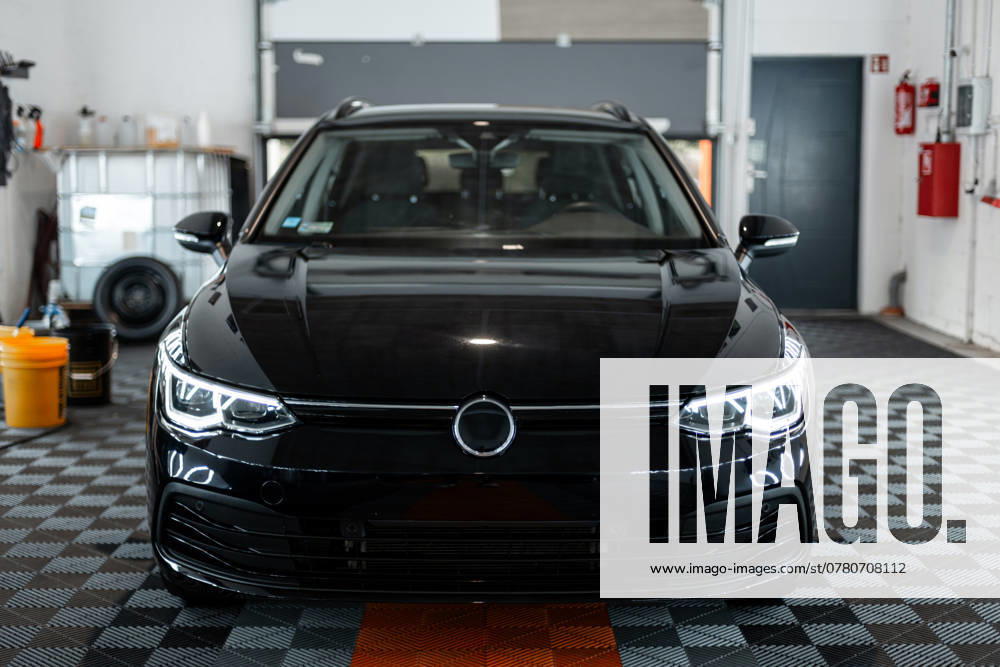 Schwarzes Auto mit optischen Scheinwerfern steht in der Garage. Autowäsche. Aufarbeitung. Reparatur