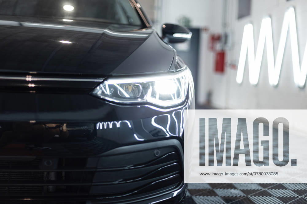 Schwarzes Auto mit optischen Scheinwerfern steht in der Garage. Autowäsche. Aufarbeitung. Reparatur