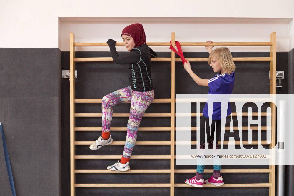 IMAGO Creative: Gesellschaft, Integration Schülerinnen an der Sprossenwand, Sportunterricht, Grundschule, Niedersachsen, Deutschland, Europa