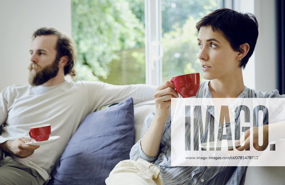 Thoughtful woman holding cup of tea after arguing with man at home model released, Symbolfoto property released, PWF01015