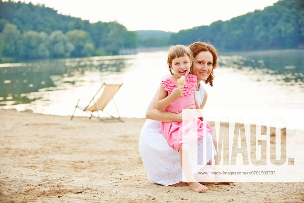 Glückliches Mädchen mit Eis und Mutter am See im Sommer ,model released, Symbolfoto