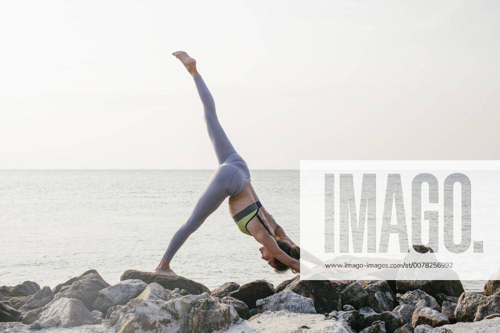 Woman practicing yoga on the beach model released Symbolfoto MOMF00060