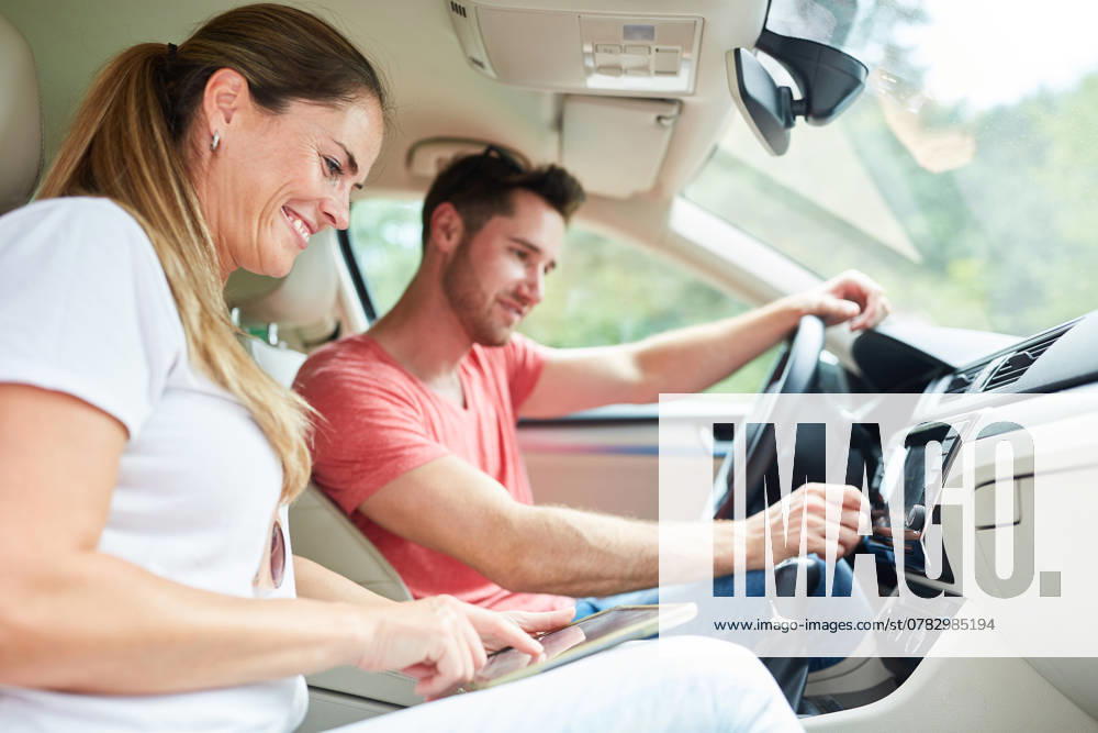 Glückliches Paar beim Auto fahren mit Tablet Computer als Navigationssystem ,model released, Symbolfoto