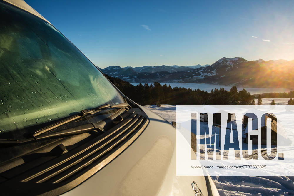 Ein Camper steht im Winter auf einem Parkplatz in den Alpen bei Sonnenaufgang im Schnee. Bödele, Vorarlberg, Österreich Winter in den österreichischen Alpen