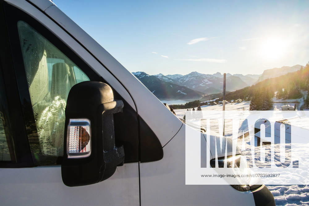 Ein Camper steht im Winter auf einem Parkplatz in den Alpen bei Sonnenaufgang im Schnee. Bödele, Vorarlberg, Österreich Winter in den österreichischen Alpen