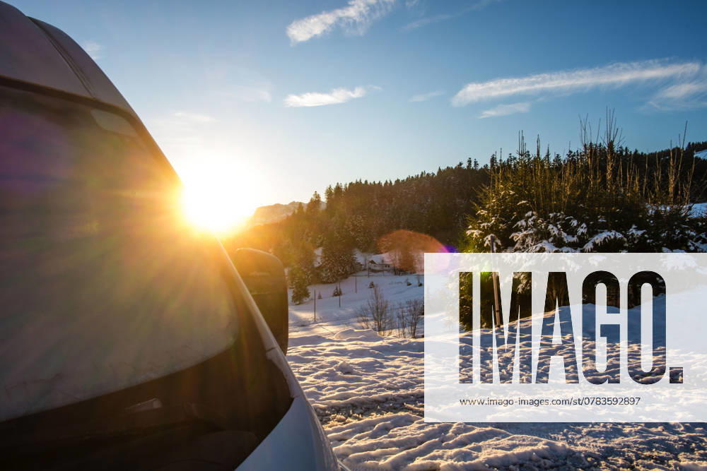 Ein Camper steht im Winter auf einem Parkplatz in den Alpen bei Sonnenaufgang im Schnee. Bödele, Vorarlberg, Österreich Winter in den österreichischen Alpen