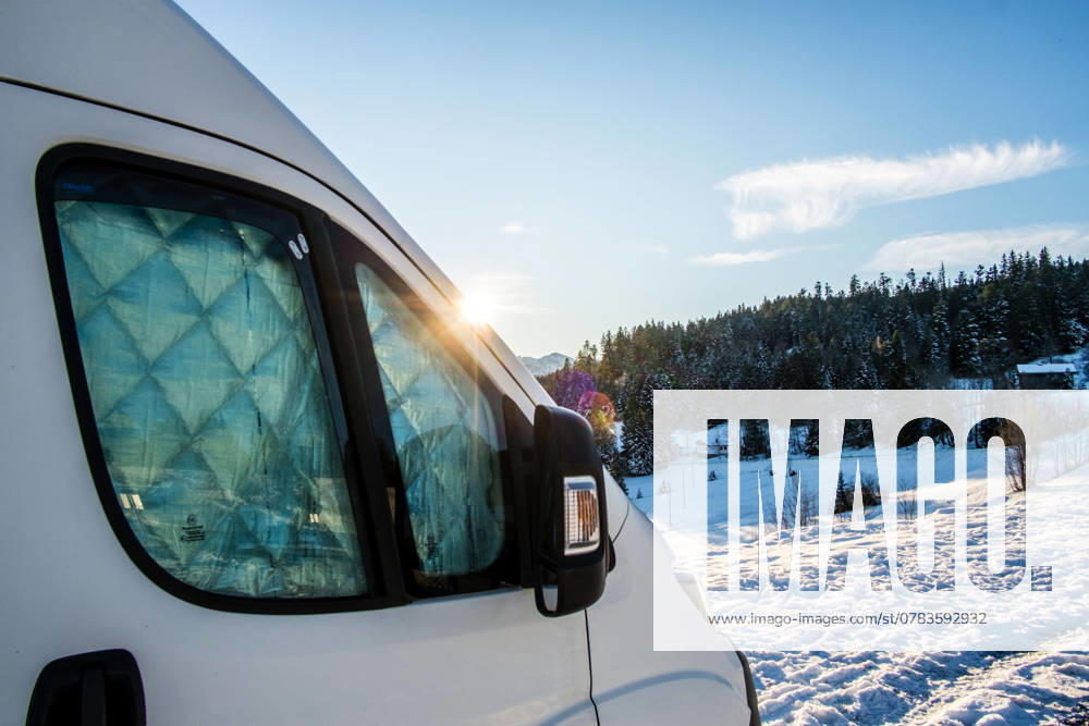 Ein Camper steht im Winter auf einem Parkplatz in den Alpen bei Sonnenaufgang im Schnee. Bödele, Vorarlberg, Österreich Winter in den österreichischen Alpen