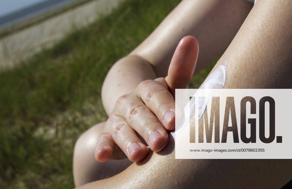 Eine Frau reibt sich den Arm mit Sonnencreme ein. Soenderho, 05.08.2013. Soenderho Deutschland