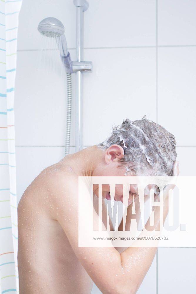 Vierzehnjaehriger Junge mit Schaum in den Haaren unter der Dusche. Duelmen, Deutschland. 12.08.2014. MODEL RELEASE vorhanden. Duelmen Deutschland